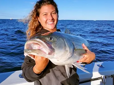 Pretty lady displays the business end of a nice striped bass.
